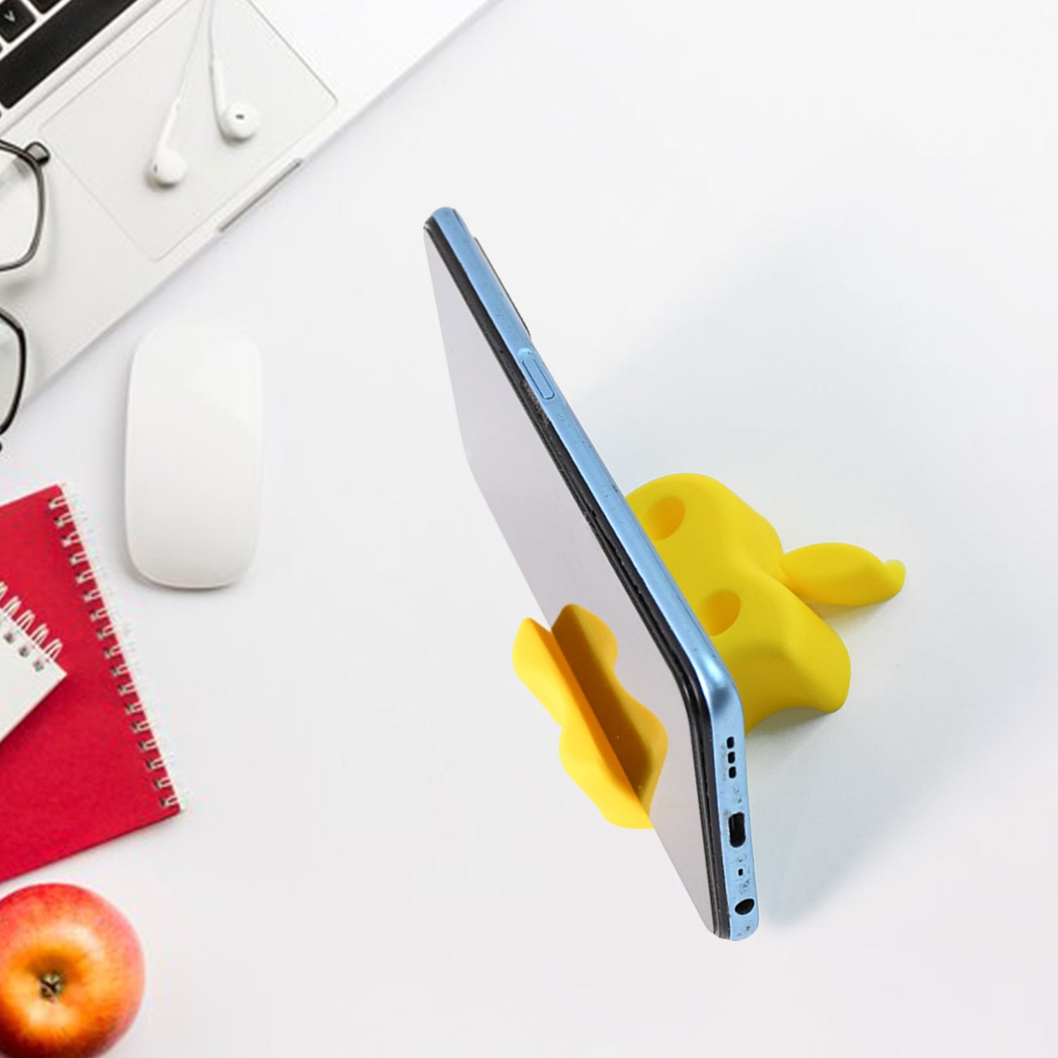 Mobile stand shaped like an apple displaying pens and phone in upright position