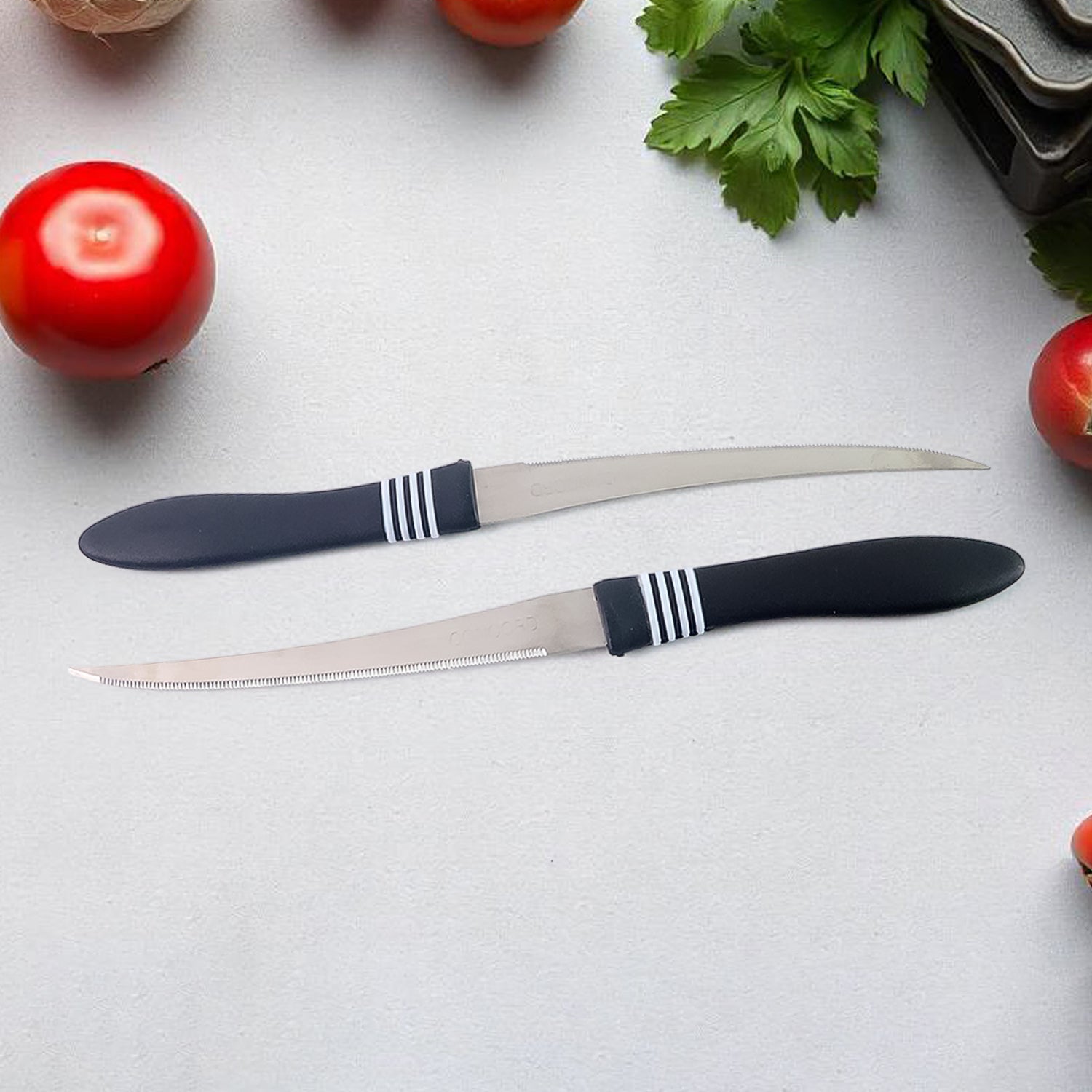 Serrated stainless steel kitchen knife slicing fresh tomato effortlessly