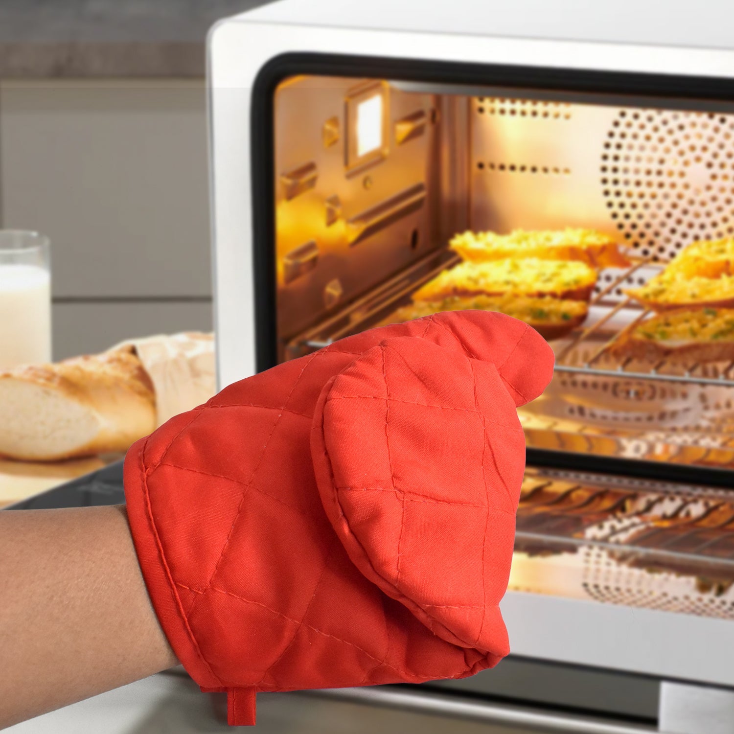 Oven mitt positioned beside kitchen cookware, illustrating its suitable size.