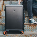Set of four flexible silicone suitcase wheel covers in black, neatly packaged.