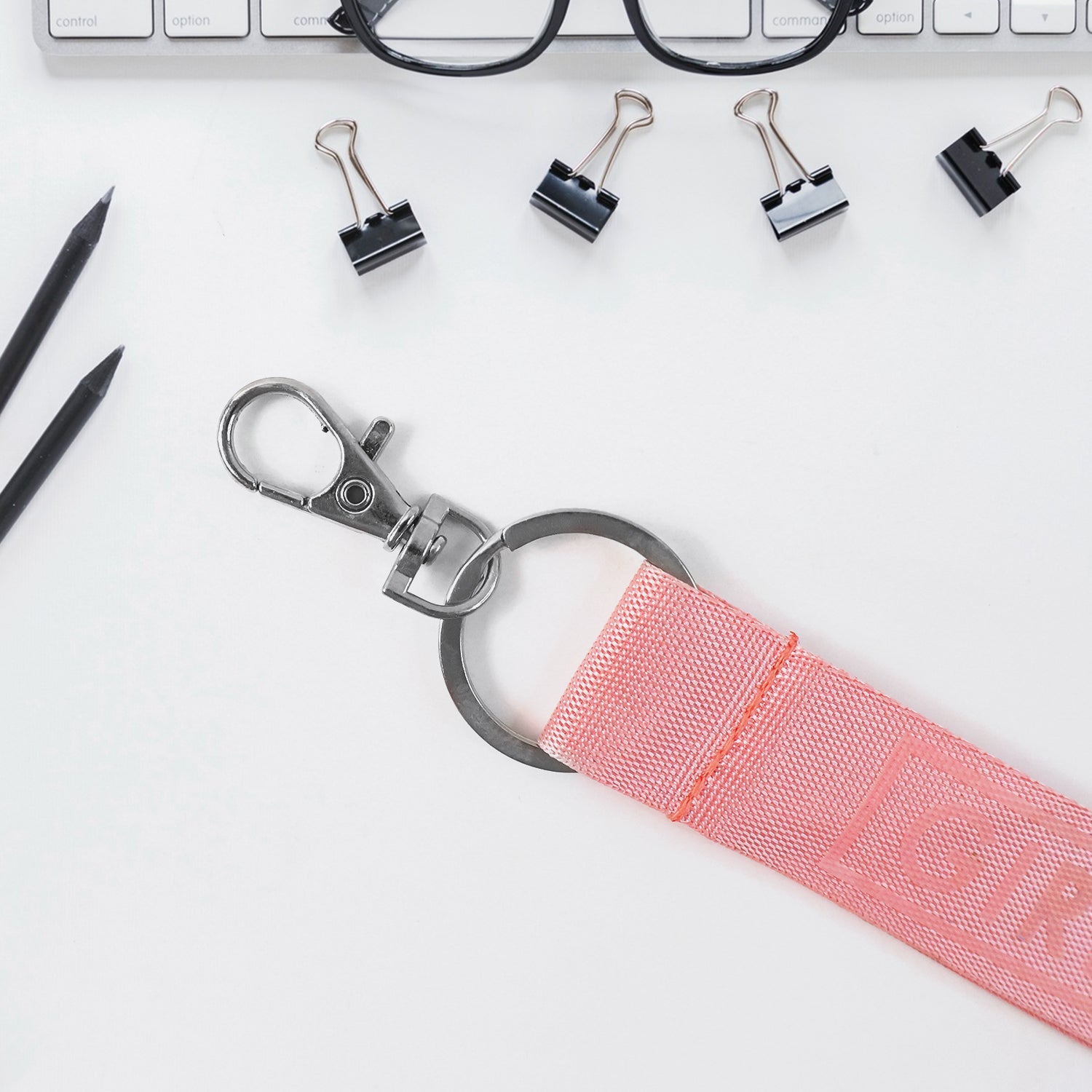Detail view of Girl Power fabric ribbon keychain with embossed text and metal keyring
