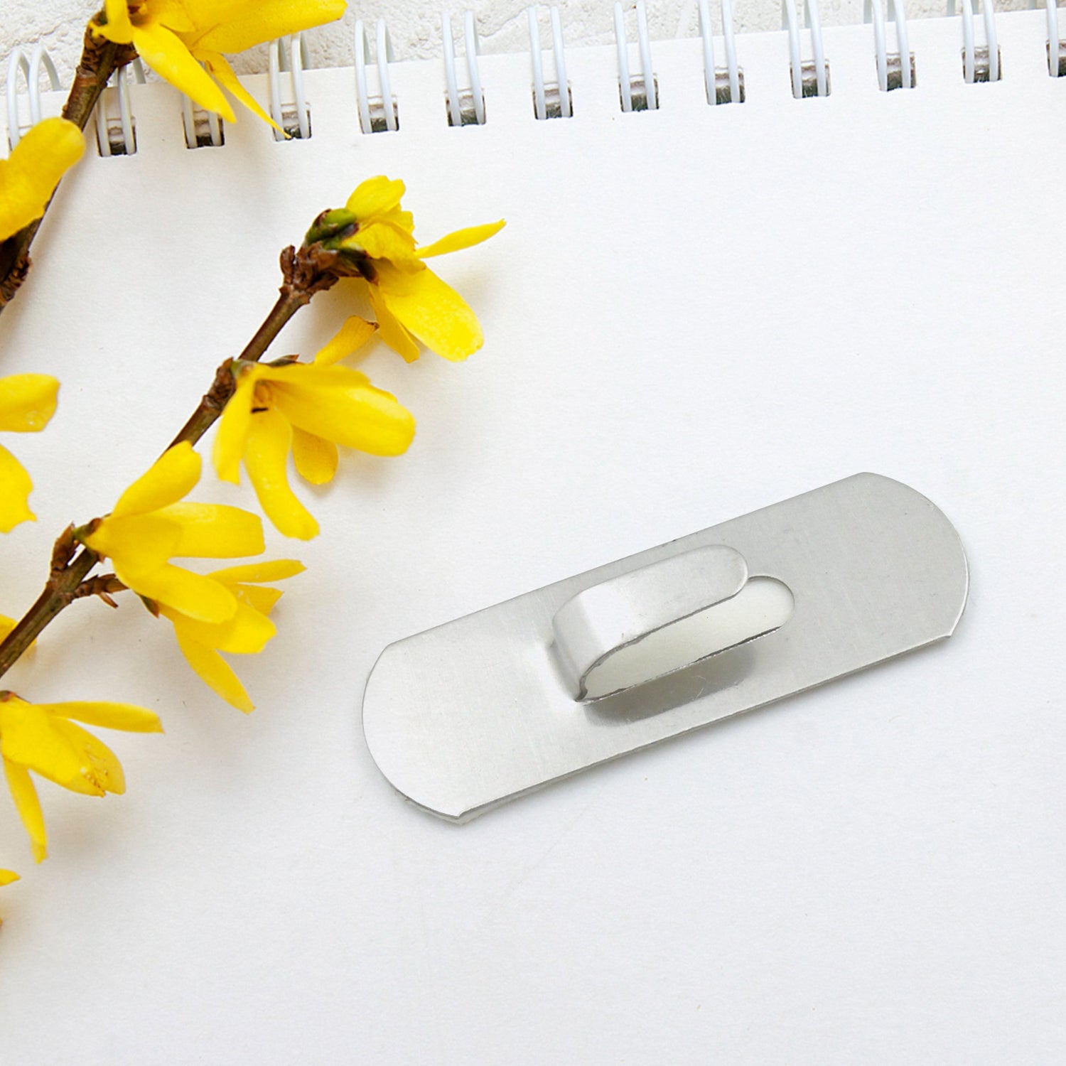 Arrangement of 18 self-adhesive stainless steel hooks on a white background.