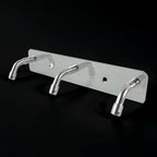 Stainless steel coat hook rack holding towels and bags