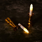 Close-up of a flameless LED candle light showing its realistic flicker and elegant gold base.
