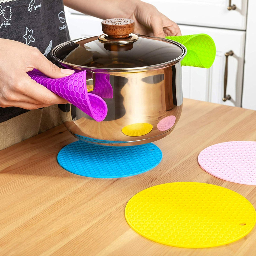 Silicone trivet hot pad protecting a dining table from a hot pot.