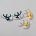 An adhesive wall hook holding a lightweight item, demonstrating its utility.