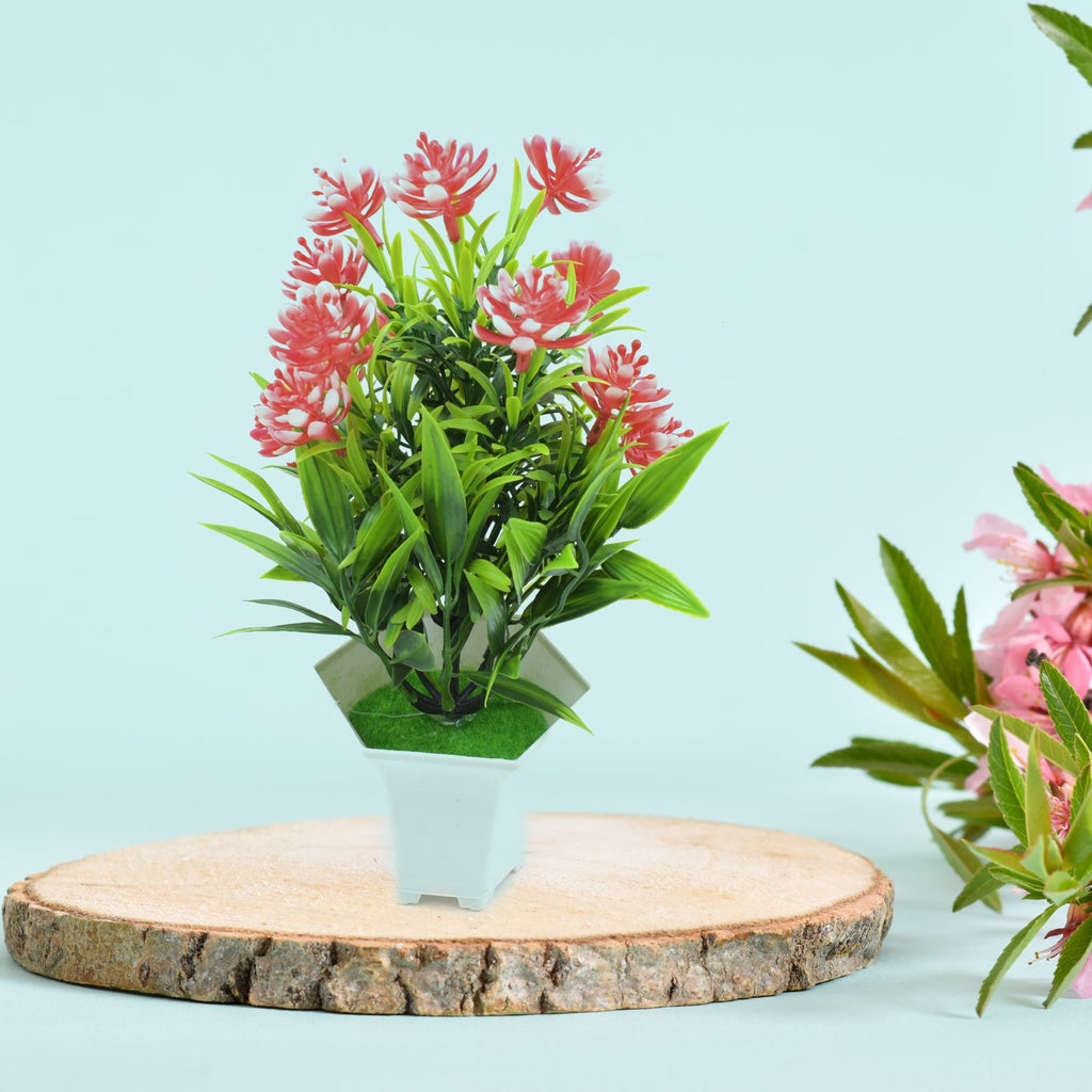 A realistic artificial flower plant with green leaves and pink blossoms in a white pot, perfect for home decor.