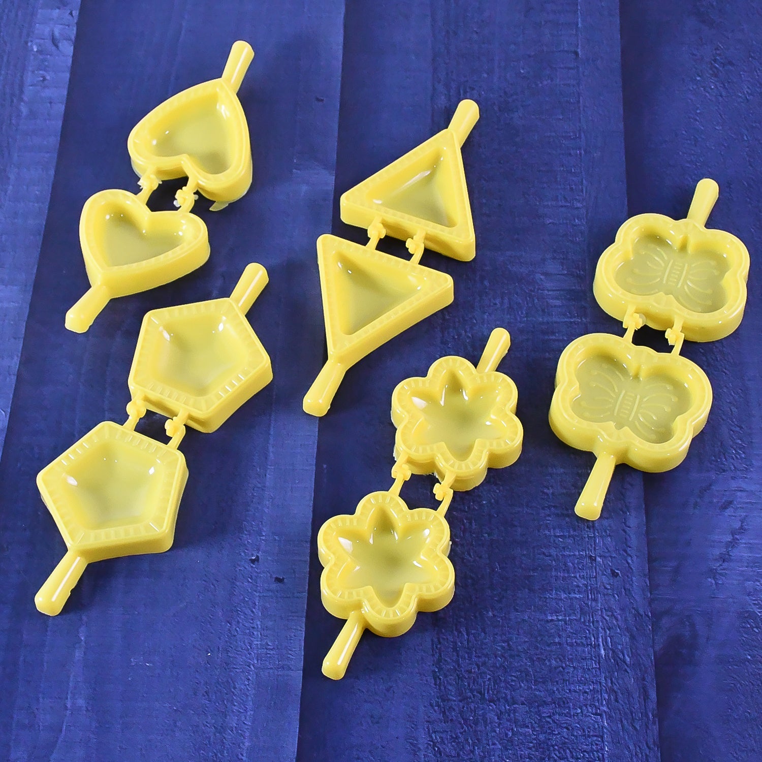 Plastic cookie cutter mould set with assorted shapes on a wooden table
