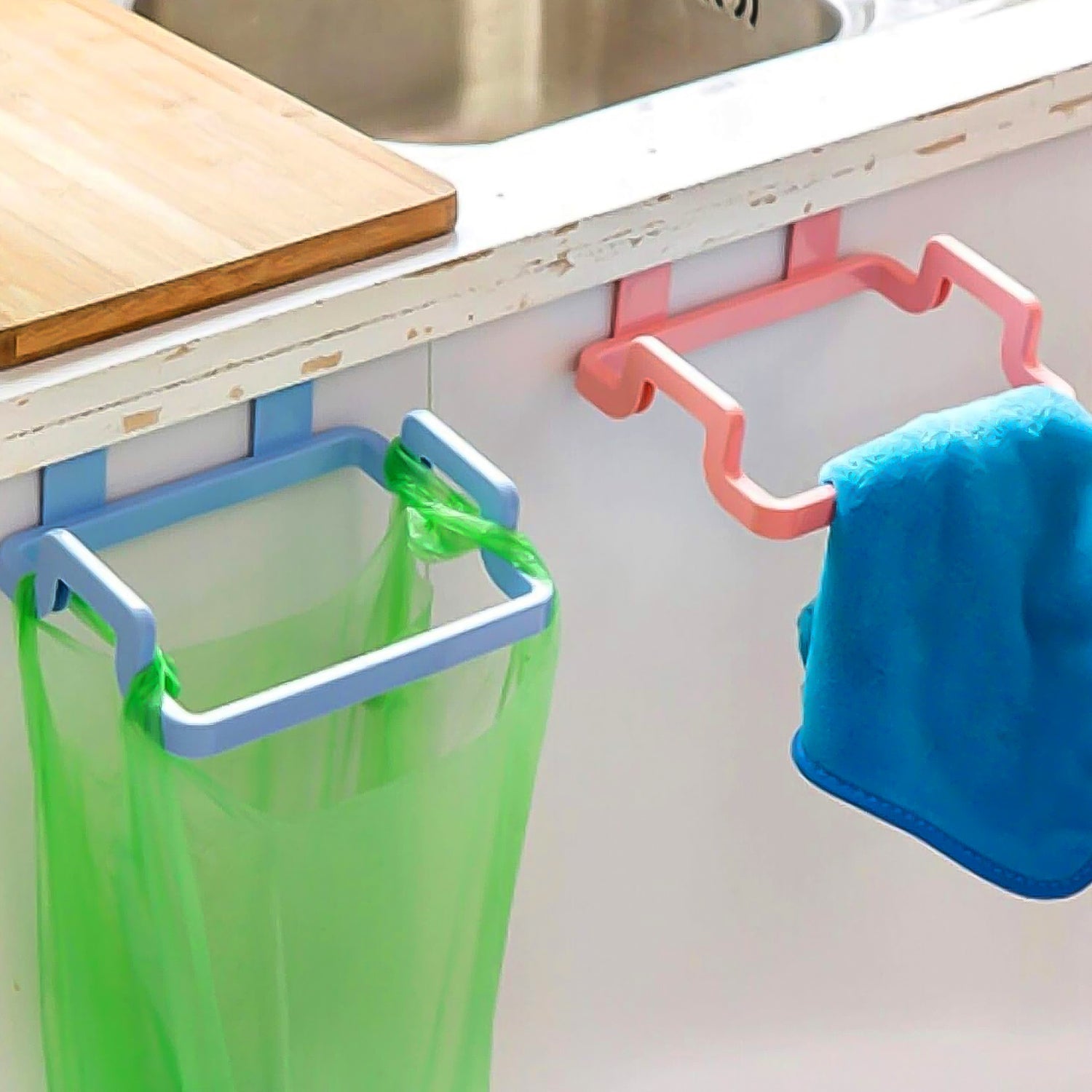 Close-up of side clips securely holding a plastic garbage bag on the rack.