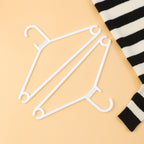 Close detail of the hook of a white plastic clothes hanger