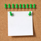Green push pin fixing paper on a cork notice board
