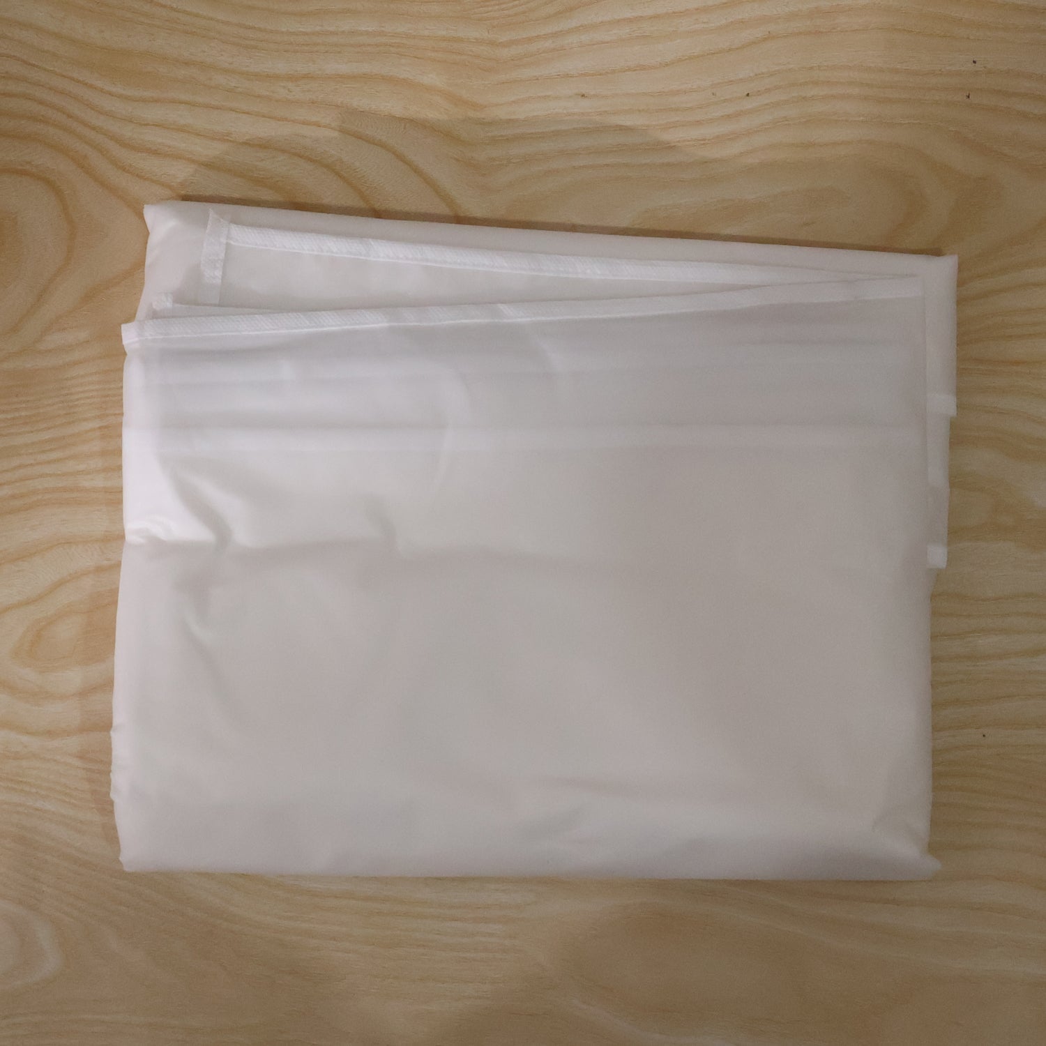 Folded suit cover, space-efficient for travel and storage.