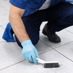 Cleaning brush scrubbing tile gaps for effective household cleaning
