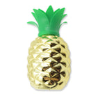 Pineapple cup with straw as part of a festive tropical party table setting.