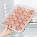 Hand pulling out a clear 24-grid plastic egg container from fridge shelf
