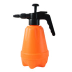 Pressure spray bottle used in garden setting for watering plants