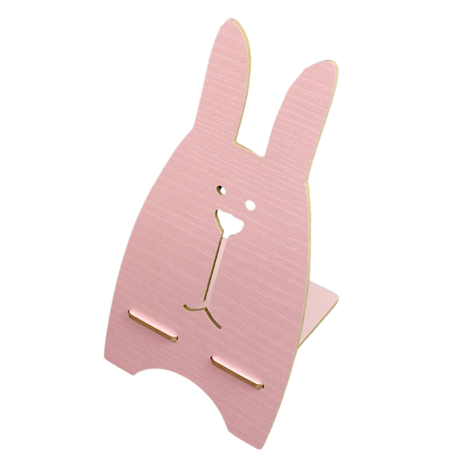 Lifestyle shot of the wooden rabbit phone stand on a table, holding a phone.