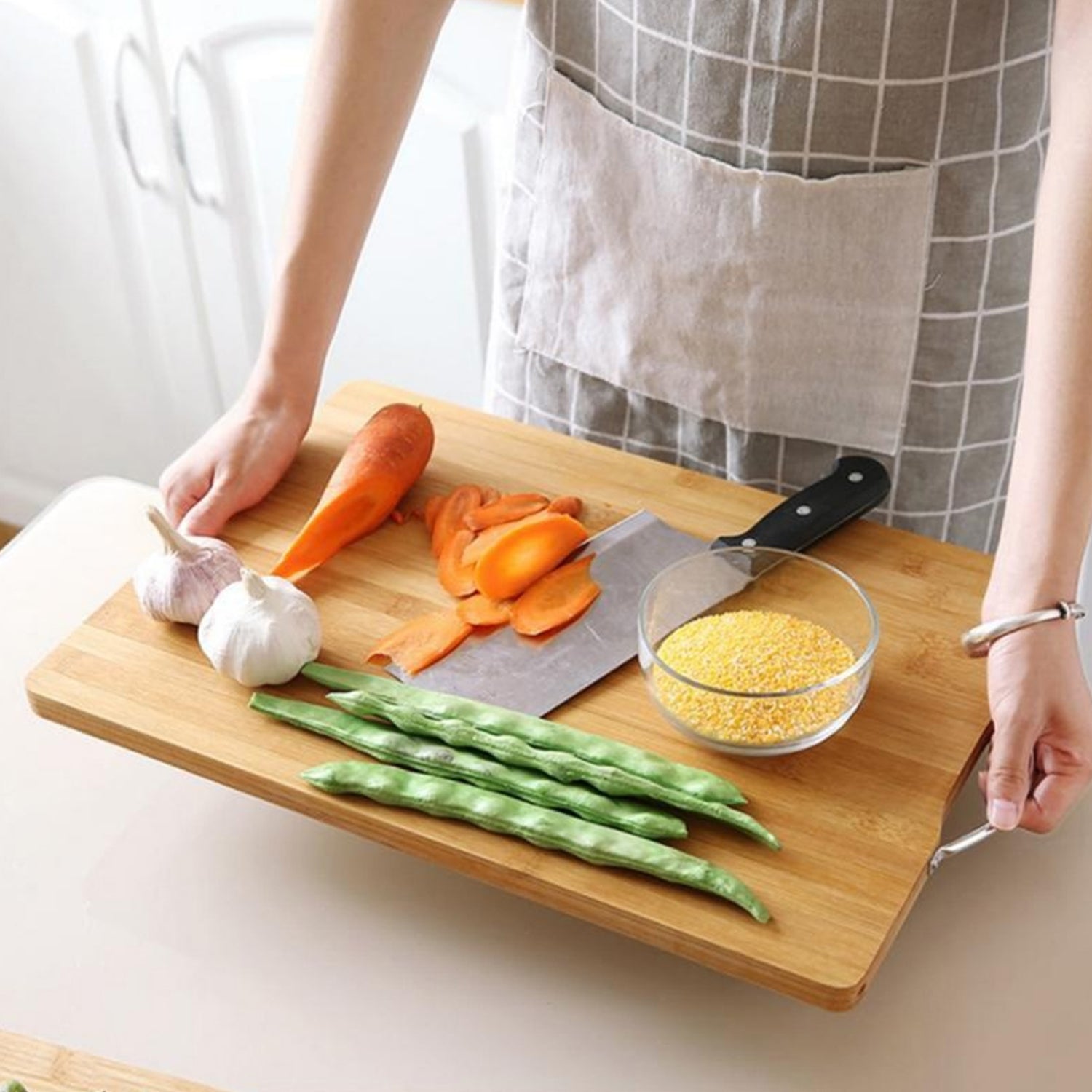 Fresh vegetables being chopped on the sturdy bamboo cutting board.