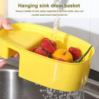 Plastic sink basket and dish drying rack holding bowls and fruits.