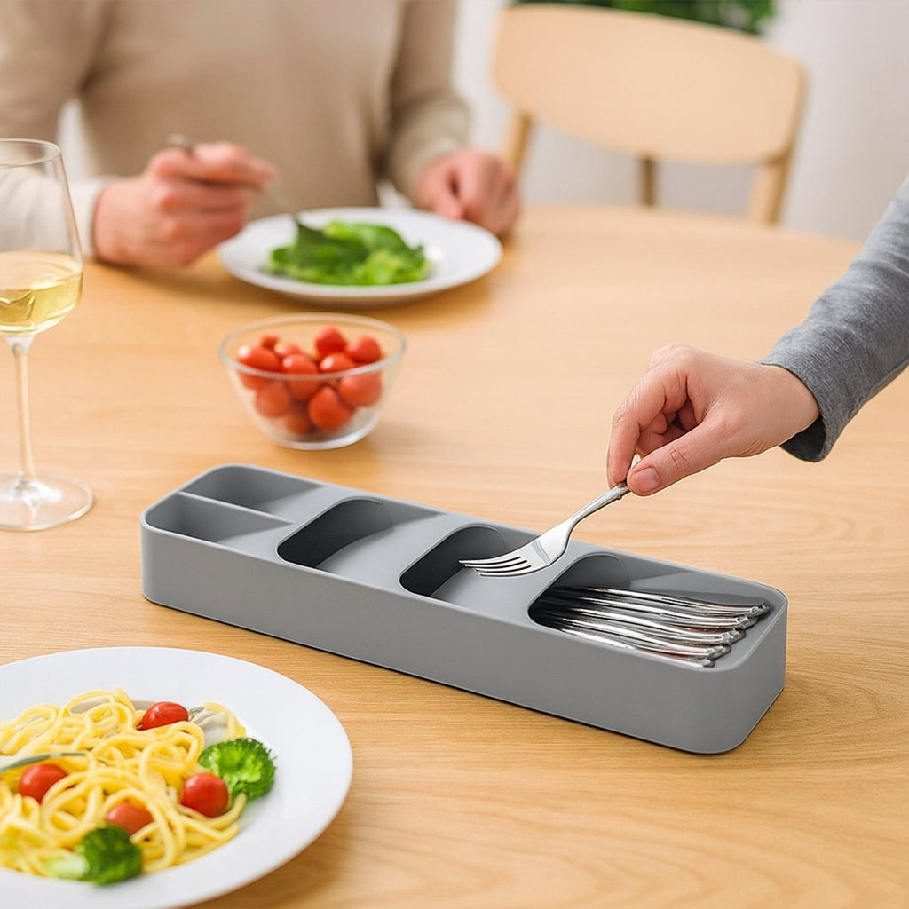 The grey cutlery tray perfectly fitted inside a kitchen drawer, ready for utensil storage.