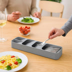 The grey cutlery tray perfectly fitted inside a kitchen drawer, ready for utensil storage.