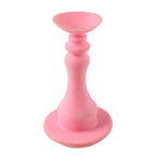 Hand holding pink washing machine door prop demonstrating use