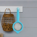 Side view of Kadak mesh strainer with plastic handle