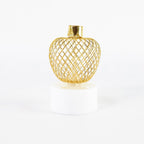 Top-down view of a single apple LED tealight candle with its intricate golden pattern.
