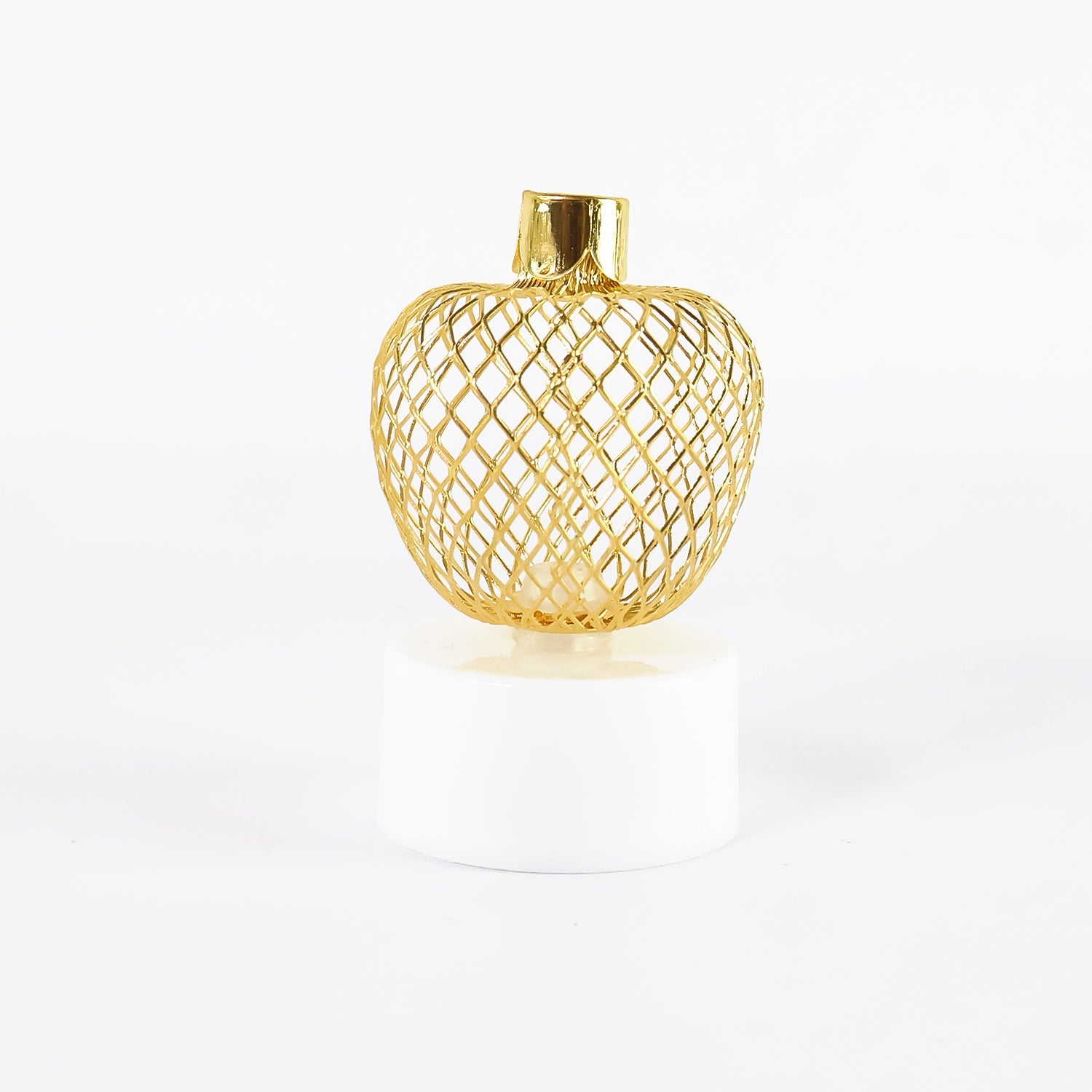 Top-down view of a single apple LED tealight candle with its intricate golden pattern.