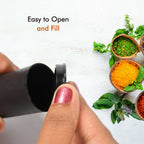 Two sleek spice dispensers enhancing a contemporary dining table setting.