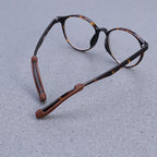 Silicone ear grips attached to eyeglass arms, demonstrating how they prevent glasses from slipping.