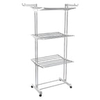 The 3-tier stainless steel drying rack with wheels, fully loaded with laundry.