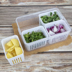 Organized fridge interior showing a clear storage container filled with fruits.