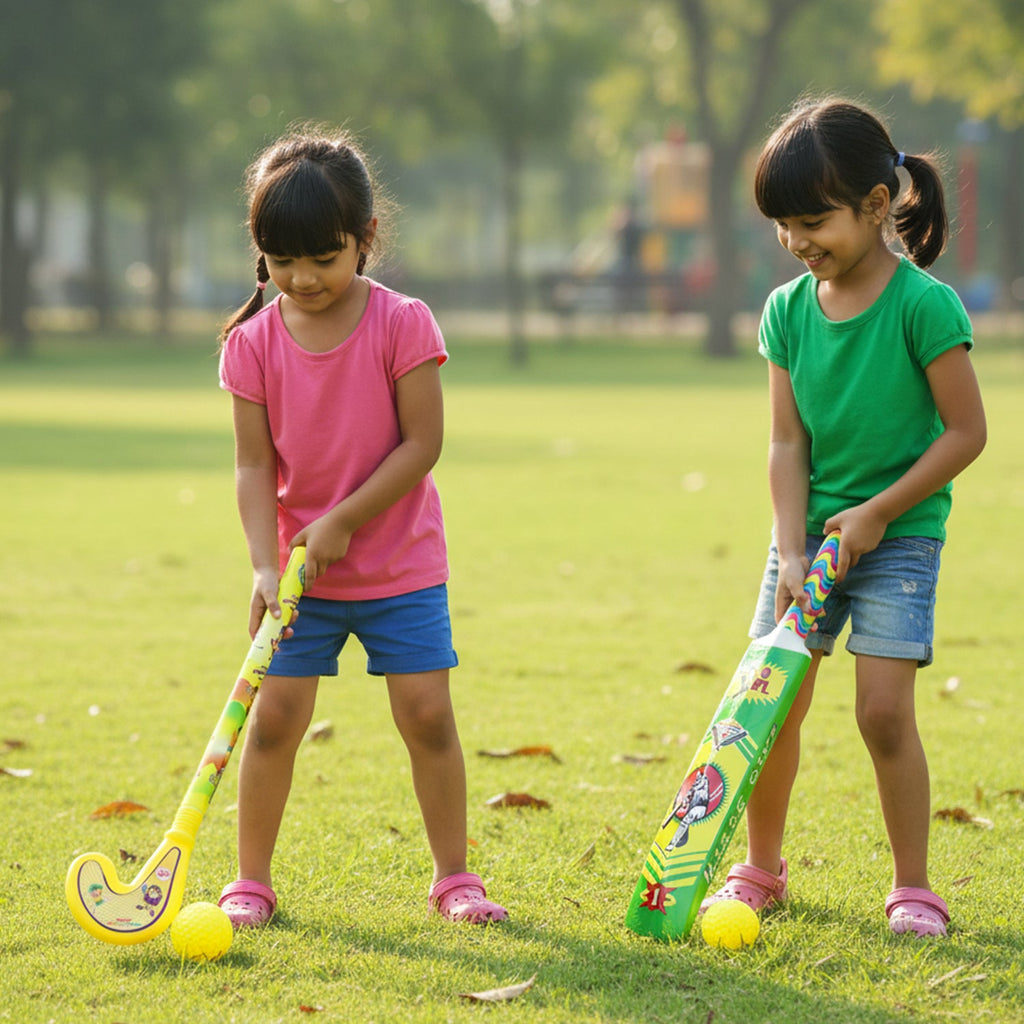 Young children happily playing with the plastic cricket bat and hockey stick outdoors.