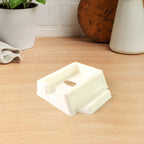 Plastic mobile phone stand mounted on wall with mobile and remote