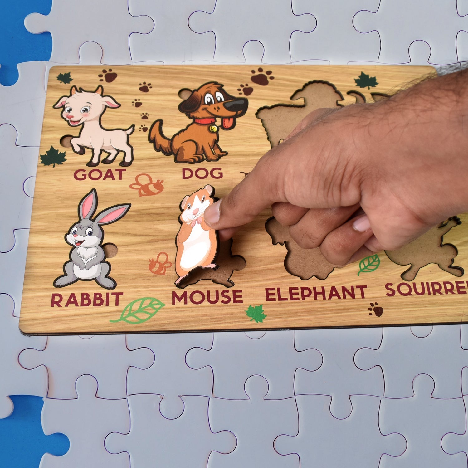 Close-up of a child's hand placing an animal piece into the wooden puzzle.