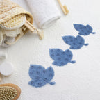 Four colorful leaf-shaped baby anti-slip bath mats with suction cups displayed.