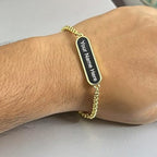 Golden bracelet with custom engraving on a display.