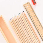 The wooden ruler and the colorful pencil box, essential accessories from the art kit.
