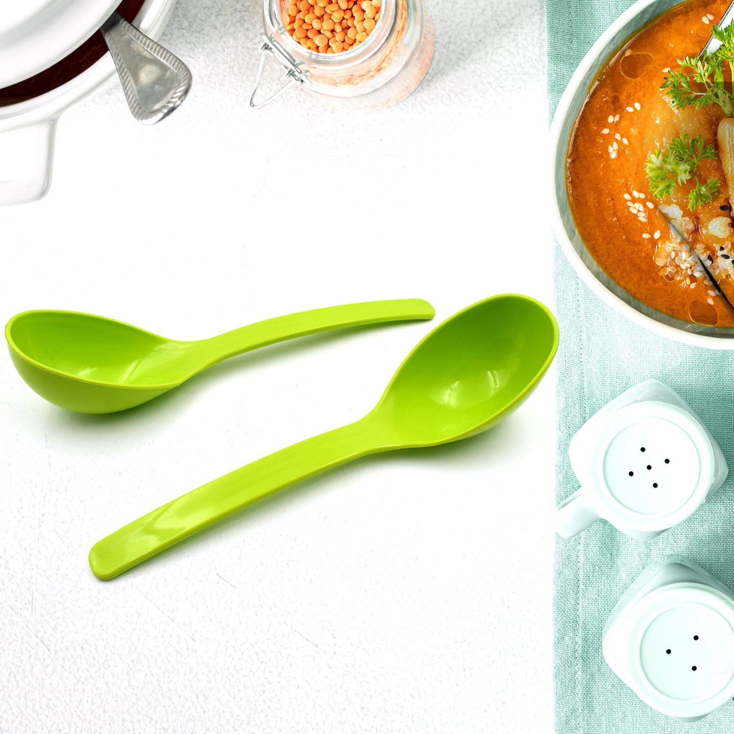 Black plastic ladle in use, stirring a flavorful curry in a pot, ideal for serving.