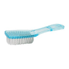 Hand holding a scrubbing brush to clean fabric of clothes.