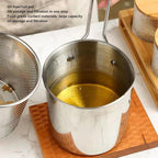 Hand lifting the strainer basket from the deep frying pot, draining excess oil from fried food.