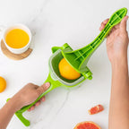 Manual juice squeezer in action, extracting fresh orange juice.