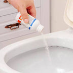 Clog remover powder dissolving soap scum and hair in a bathroom sink drain.