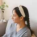 Woman wearing soft ribbed knot hairband with padded design, side view