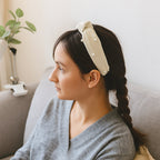 Woman wearing soft ribbed knot hairband with padded design, side view