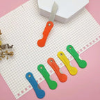 Precision mini paper cutter knife in action, cutting a piece of paper.