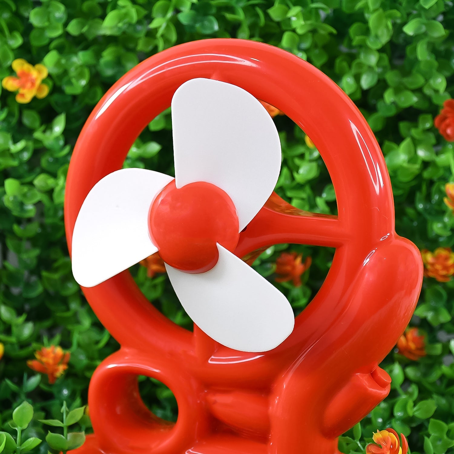 Red portable desk fan, showcasing its compact size and modern aesthetic.
