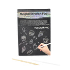 Child drawing detailed doodle on colorful scratch art sheet