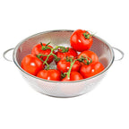 Stainless steel colander with handle resting on a kitchen countertop.